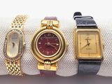 Trois montres-bracelets pour femmes sont posées sur un tissu blanc