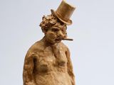 a statue of a man with a top hat and a cigarette in his mouth