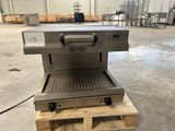 une photo d'un grill professionnel dans un entrepôt, avec des palettes