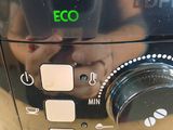 a close up of a coffee maker with a person taking a picture