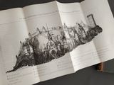 someone is holding a book with a drawing of a city on it