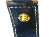 the handle of a black purse with a gold ring on it