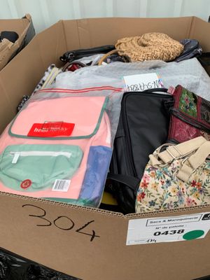 une boîte en carton remplie de nombreux vêtements et sacs