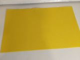 un gros plan d'un tapis jaune posé sur une surface blanche