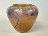a brown vase with blue designs on it on a white surface