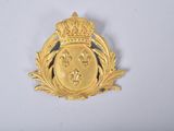 une image représentant un insigne de couleur dorée orné d'une couronne