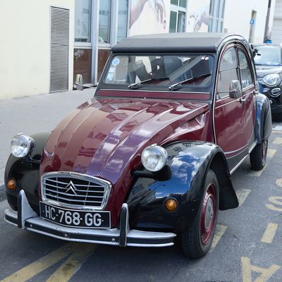 une voiture rouge et noire garée au bord de la rue