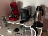 a coffee maker sitting on top of a shelf next to a coffee pot