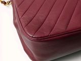 a close up of a red purse on a white surface