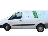 une camionnette blanche avec un autocollant vert sur le côté