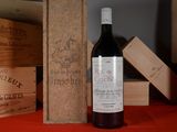 a bottle of wine sitting on a table next to wooden boxes