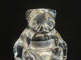 un ours en verre posé sur une surface noire