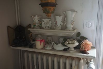 un radiateur dans un coin d'une pièce remplie de vases et de bougies