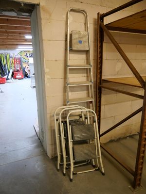 une échelle appuyée contre un mur, à côté d'une autre échelle