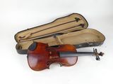 a violin in a case on the ground next to a violin