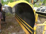 a man that is standing next to a yellow snow plow