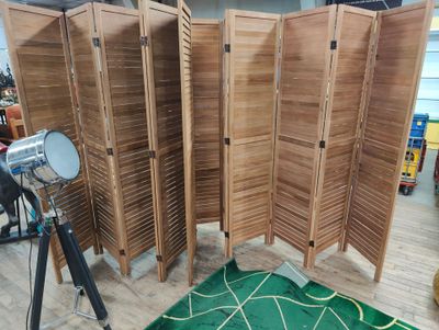 a room divider made out of wood with a camera on the floor