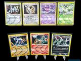Plusieurs cartes Pokémon sont alignées sur une surface noire