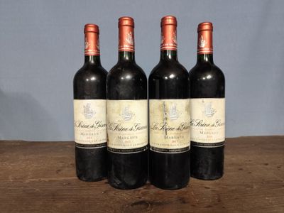 three bottles of red wine sitting on top of a wooden table