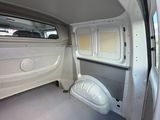the interior of a van with the door open and a toilet in the back