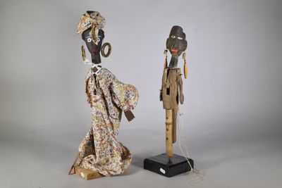deux figurines en bois représentant des personnes en costume traditionnel, debout l'une à côté de l'autre