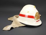 an image of a white helmet with a red stripe and a gold eagle on it
