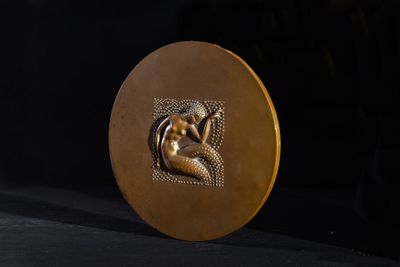 a gold medal with a picture of a woman on it