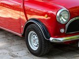a small red car parked on the side of the road