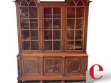 a wooden china cabinet with glass doors on it