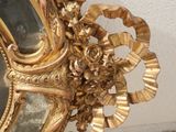 a mirror with a gold frame hanging on the wall