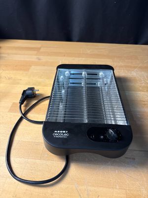 a black heater on a wooden table with a black background
