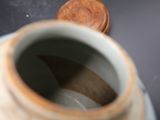 a vase with a wooden lid sitting on a table