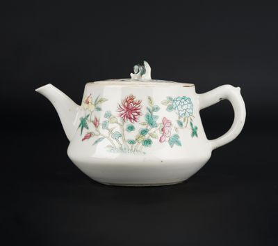 une théière blanche ornée d'un motif floral