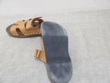pair of brown sandals on a gray surface with a white background
