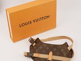 un sac Louis Vuitton et une boîte posés sur la table