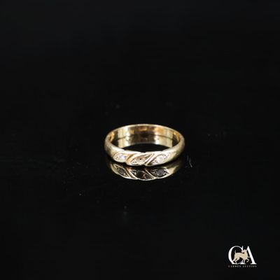 gros plan d'une bague en or sur une surface noire