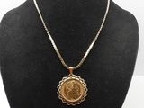un collier avec une pièce d'or sur un mannequin noir