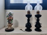 two lamps sitting on a window sill next to a vase of flowers