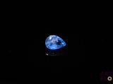 a close up of a blue diamond on a black surface