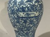 un vase bleu et blanc posé sur une table