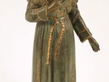 statue d'une femme vêtue d'une robe verte et coiffée d'un chapeau