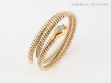a close up of a gold and diamond snake ring