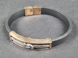 silver and gold bracelet with square clasps on a gray surface