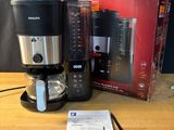 une cafetière, un mixeur et une tasse posés sur une table