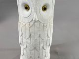 a white owl figurine sitting on a table