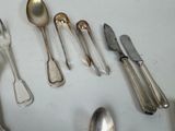 a lot of silver spoons and spoon knives on the table