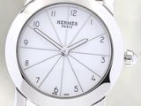 the watch has a white dial and a brown leather strap