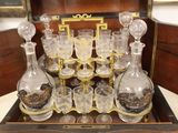 bottles and glasses in a wooden case on a table