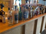 many bottles of alcohol lined up on the bar