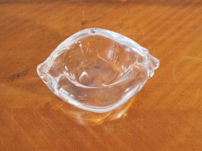 a glass ashtray sitting on a wooden table